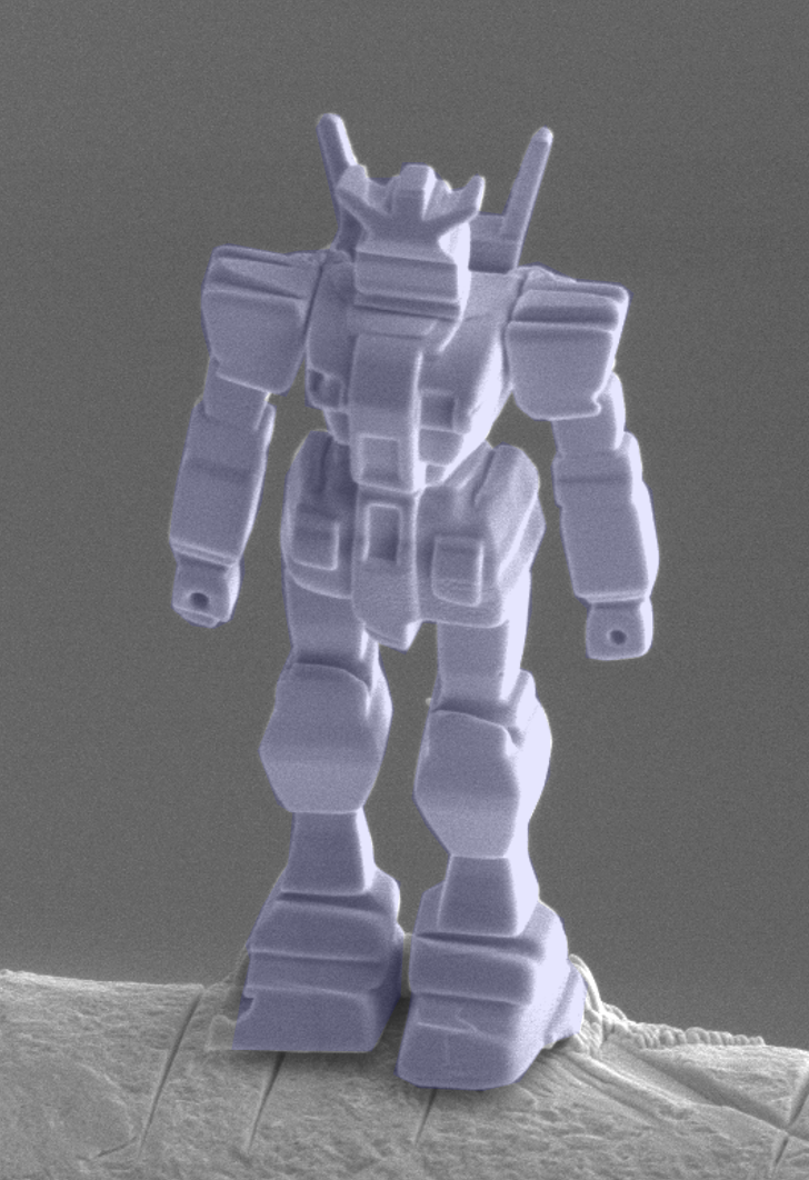 Electron micrograph of a purple robot sculpture, 18 μm tall, sculpted from a Weyl ferromagnet